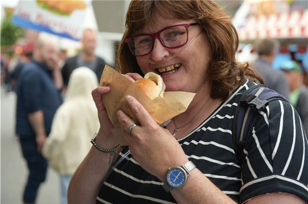 Hage feiert: Gute Laune im Dauerregen Darf bei einem Küstenfest natürlich nicht fehlen: der Biss ins herzhafte Fischrbötchen.