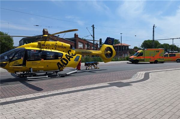 Ein Hubschrauber mit der Aufschrift ADAC steht in der nähe des Hauptbahnhofes Norden. Daneben steht eine Transportliege. Im Hintergrund ist ein Rettungswagen zu sehen.