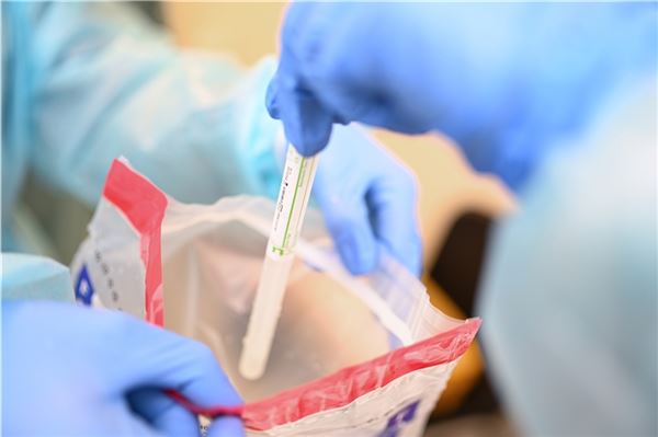 Ein Arzt steckt ein Teströhrchen in eine Plastiktüte, um sie an ein Labor zu senden.  Foto: DPA