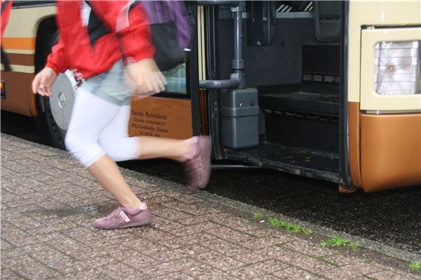 Schulbusse am Limit Ein Kind springt aus dem Schulbus.