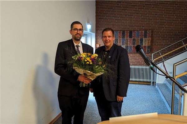 Florian Eiben (rechts) überreicht dem neuen Stadtbaurat einen Strauß Blumen als Willkommensgeschenk. Foto: Merlin Klinke