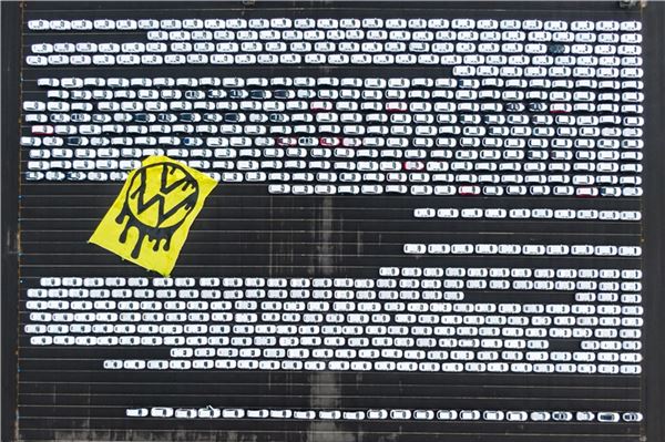 Nach Greenpeace-Aktion bei VW: Polizei ermittelt Greenpeace-Aktivisten breiten ein riesiges Protesttransparent über Autos aus, die auf dem Verladeplatz von VW stehen (Aufnahme mit Drohne).
