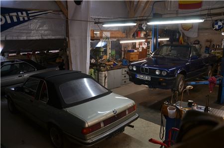 Im Vordergrund steht der von Harry Janssen komplett restaurierte E21 323i als Baur Cabrio. Auf der Hebebühne, die Janssen günstig und zuvor noch nie benutzt von einem Autohaus erwarb, steht aktuell das E30 Cabrio, das nur „Mr. Bean“ genannt wird. Fotos: Marc Wenzel