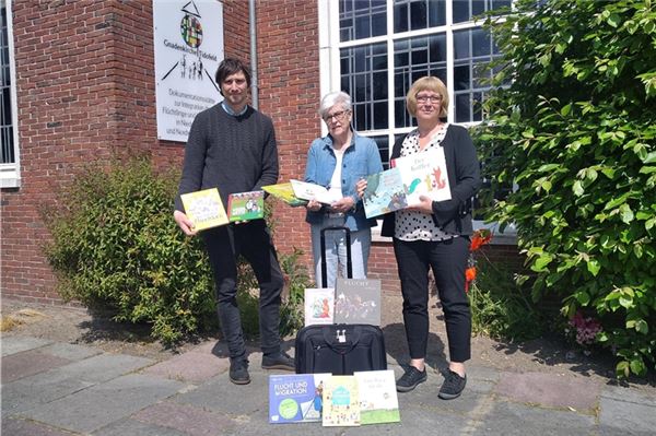 Jutta Renken-Sprick (r.) überreicht Anna Jakobs und Lennart Bohne von der Dokumentationsstätte die Bücher- und Materialientasche. Foto: privat