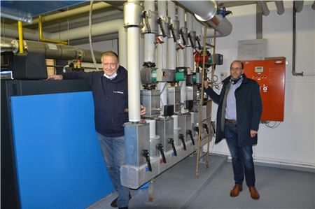 Udo Weilage (links) und der Dornumer Bürgermeister Michael Hook stehen stolz vor dem neuen Blockheizkraftwerk. 