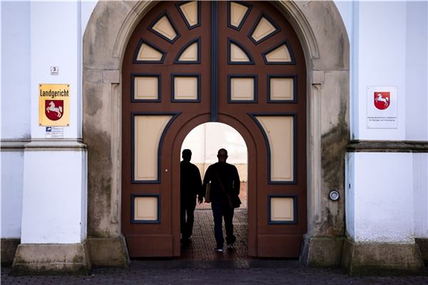 Zwei Leute betreten den Innenhof vom Landgericht Aurich.