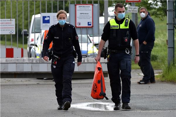  Zwei Polizisten haben einen der Säcke, in denen Greenpeace-Aktivisten läuft Zündschlüssel von VW-Fahrzeugen eingesammelt hatten, sichergestellt. 