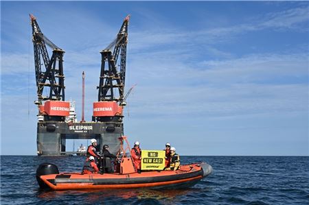 30.07.2024, Niedersachsen, Borkum: «No New Gas» steht auf einem Banner an einem Schlauchboot. Greenpeace-Aktivisten protestieren rund 20 Kilometer nördlich der niederländischen Insel Schiermonnikoog gegen die Förderung von Erdgas. Die Klimaschützer aus Deutschland und den Niederlanden umrunden mit Schlauchbooten die Arbeitsschiffe des niederländischen Energiekonzern One-Dyas. (zu dpa: «Umweltschützer blockieren weiter Erdgasbohrung auf Nordsee») Foto: Lars Penning/dpa +++ dpa-Bildfunk +++