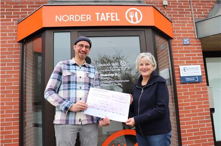 Adam Chmielarz überreicht den symbolischen Scheck an Barbara Hölscher von der Norder Tafel. 
