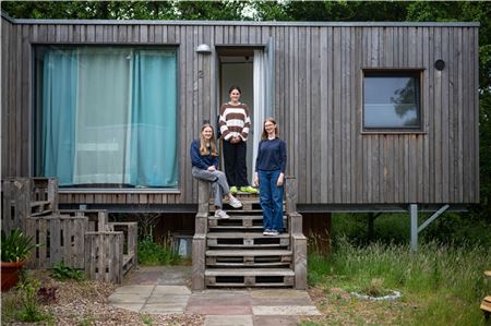 Anna Kahmann (v. l.), Paulina Ehrlichmann und Hannah Böttcher, Schülerinnen des Internats Hermann-Lietz-Schule Spiekeroog, vor einem der Tiny-Häuser. Foto: Sina Schuldt/dpa