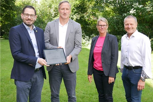 Baudezernent Eiko Ahten (l.) und Judith Vogel (2. v. r.), Leiterin des Amtes für Bauordnung, Planung und Naturschutz, vom Landkreis Aurich überreichen die digitale Baugenehmigung für die Zentralklinik an Geschäftsführer Dirk Balster (2. v. l.) und Projektleiter Andreas Epple (r.).