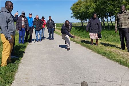 Beim gemeinsamen Boßeln am Deich zeigt sich manches ugandische Naturtalent – hier: Bischof Wilson Kitara bei einem gelungenen Wurf. Foto: privat