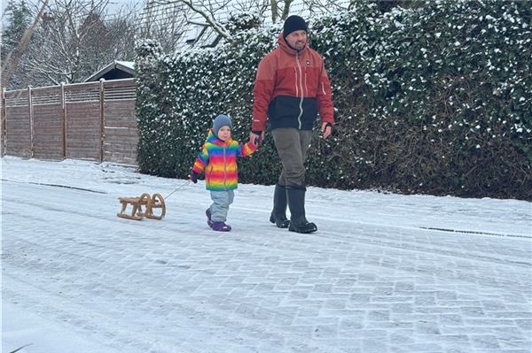 Das Wetter muss ausgenutzt werden: Vater und Tochter auf dem Weg zum Rodeln in Süderneuland.
