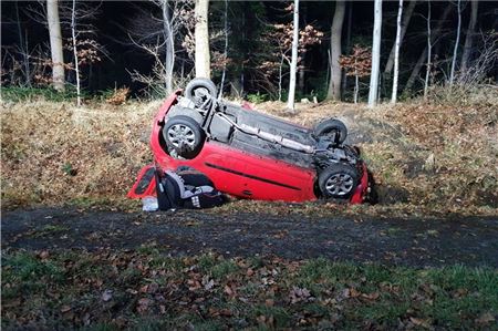 Der Unfallwagen liegt auf dem Dach im Straßengraben. 
