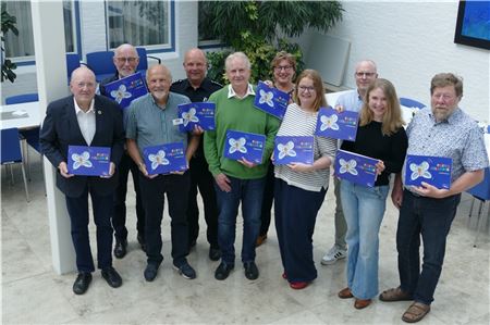 Die „Eltern“ von Fritz Filapper, Brigitte Kleemann (vordere Reihe, Dritte von rechts) und Heinz Kleemann (links daneben) freuen sich gemeinsam mit den Verantwortlichen von Brandkasse, Plattdüütskbüro und Oostfreeske Taal über 25 Jahre erfolgreiche Zusammenarbeit. Foto: Werner Jürgens