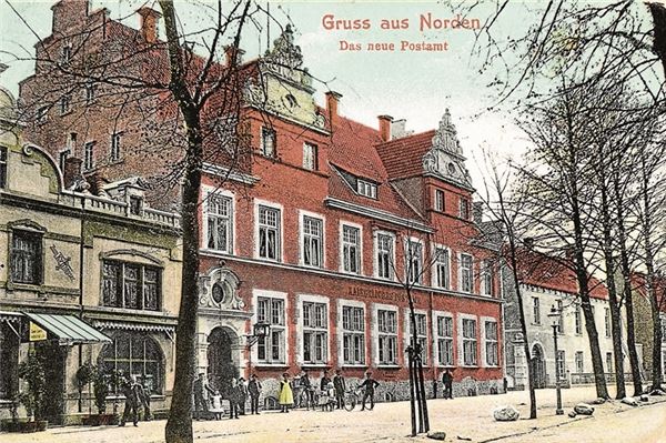 Die kolorierte Ansichtskarte zeigt den 1906/1907 errichteten Neubau des Kaiserlichen Postamtes in Norden kurz nach der Vollendung.
