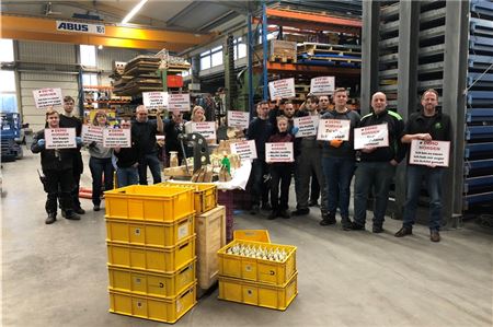 Die Organisatoren und Unterstützer mit einer Auswahl an Plakaten. Derzeit füllen sie Erbsen in Tüten ab, die während der Demo an die Bürger verteilt werden sollen. Foto: Hauke Eilers-Buchta