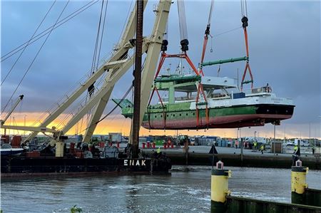 Die „Spiekeroog IV“ wurde am Donnerstagmorgen mittels Schwimmkran zurück ins Hafenbecken von Neuharlingersiel befördert.