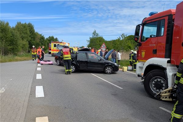 Ein Feuerwehrfahrzeug, im Hintergrund die Feuerwehr und die Verunfallten Fahrzeuge