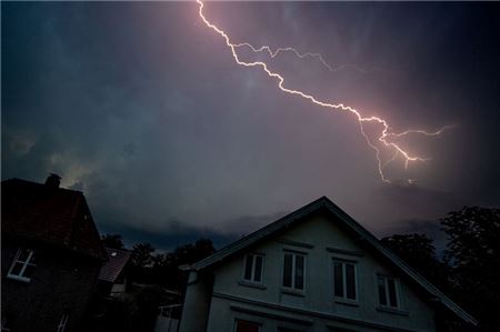 Ein Blitz zuckt während eines Gewitters über den dunklen Abendhimmel im Stadtzentrum. (zu dpa: «Unwetter im Norden führen zu zahlreichen Einsätzen»)