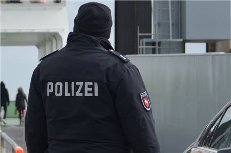 Ein Polizist steht am Hafen von Norderney.