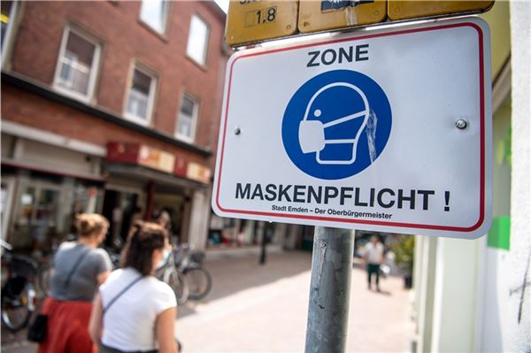 Ein Schild weist auf die bestehende Maskenpflicht hin. Nach Wochen mit einer angespannten Corona-Lage gilt die Stadt Emden von Freitag an nicht länger als Hochinzidenzkommune. 