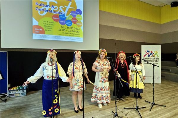 Eine Gruppe ukrainischer Frauen singt und tanz in traditionellen Kleidern.