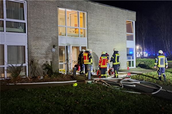 Feuerwehrleute besprechen nach der Evakuierung des betroffenen Traktes die Situation.