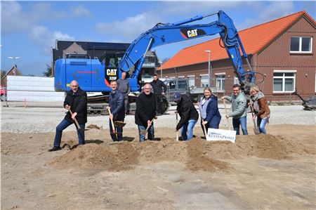Hages Bürgermeister Erwin Sell, Dieter Krott von der Kassenärztlichen Vereinigung, Frank Stieg von der Deutschen Apotheker- und Ärztebank, Investor Rimt Wortberg,Ärztin Eva Wortberg, Dr. Axel Ungerland und seine Frau Heike (von links) beim ersten Spatenstich für das neue Ärztehaus. Im Hintergrund Baunternehmer Harald Janssen und Marvin Herms von der gleichnamigen Erdbaufirma aus Großheide.