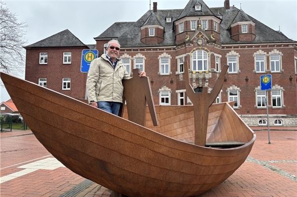 Hans Ludwig Janssen in einem großen Metallboot vor dem Kreishaus. Das Kunstwerk wurde von Flüchtlingen geschaffen. Titel: „Wir sitzen alle in einem Boot“.
