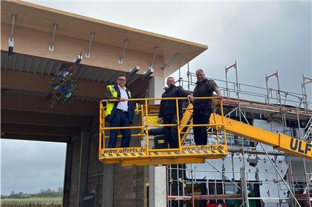 Hoch hinaus (aber diesmal ohne Hubschrauber): Olaf Weddermann von den Inselfliegern, Udo Hinrichs und Polier Roman Fischer (beide vom Unternehmer Tell Bau) feierten das Richtfest als Meilenstein beim Bau des neuen Hangars