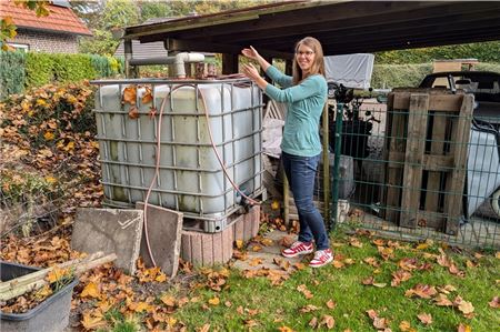 Ingenieurin Kerstin Wunder erklärt die Ausmaße der Biogasanlage anhand eines Regenauffangbehälters. In der Größe könnten 25 Kilogramm Tiermist am Tag genutzt werden. Foto: Merlin Klinke