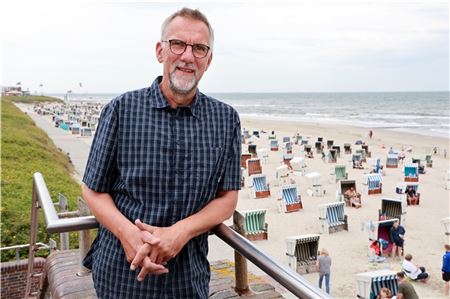 Inselpastor Jan Janssen an der Strandpromenade am Ortskern von Wangerooge. Foto: Dieter Sell/epd