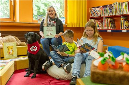 Jannes und Lena lesen Lesehündin Aila vor, Frauchen Christina Saathoff freut sich über den Erfolg des Konzepts. Foto: Meret Edzards-Tschinke