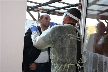 Joachim Geiken (r.) von der DRK-Ortsgruppe Dornum führt ein Teststäbchen in die Nase von Bürgermeister Hook ein. Das Ergebnis war erwartungsgemäß negativ.