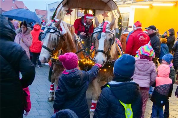 Nikolaus fährt mit einer Kutsche über die Straße, Kinder freuen sich