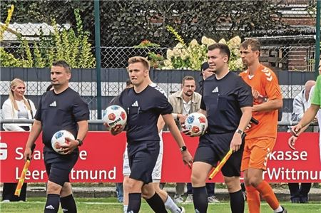 Los geht’s. Schiedsrichter Maron Arends (Mitte) mit seinen Assistenten Hilko Rosenweg und Michael Hinrichs laufen vor einem Landesliga-Spiel in Firrel ein.