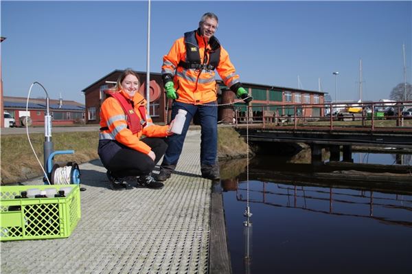 Martina Ritter und Carsten Didi nehmen eine Wasserprobe in Emden.