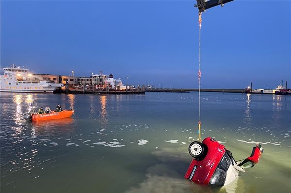 Auto stürzt ins Hafenbecken: Frau und Hund retten sich in Norddeich Mit einer Kette und einem Kran wurde das Auto aus dem Wasser gezogen.