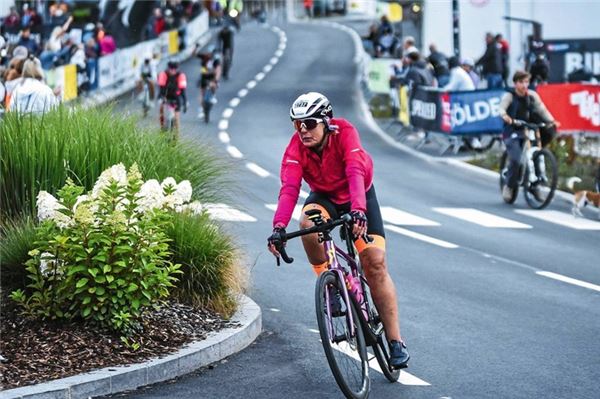 Mit Konzentration und Tempo. Hilde Buss setzt im Ort Sölden zur Kurve an – am Straßenrand feuern die Zuschauer die Fahrerinnen und Fahrer an.