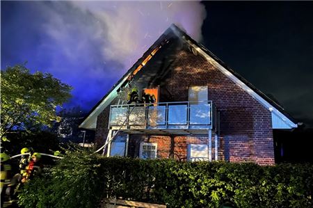Mitglieder der Freiwilligen Feuerwehr rücken in der Nacht zum Dienstag unter Atemschutz in das Innere des brennenden Gästehauses vor.