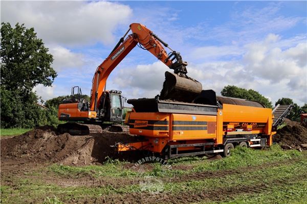 Umzug mit Maschinen, Team und Plänen Mutterboden sieben.