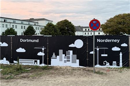 Noch tut sich hinter dem Bauzaun an der Weststrandstraße wenig. Doch ab Oktober sollen die Bagger dann endlich richtig rollen. Foto: Noun