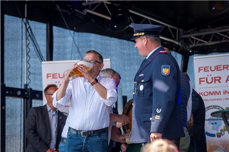 Schirmherr und Landrat Olaf Meinen und Stadtbrandmeister Thomas Kettler eröffnen die Veranstaltung mit einem kräftigen Schluck Bier vom Fass – frisch gezapft.