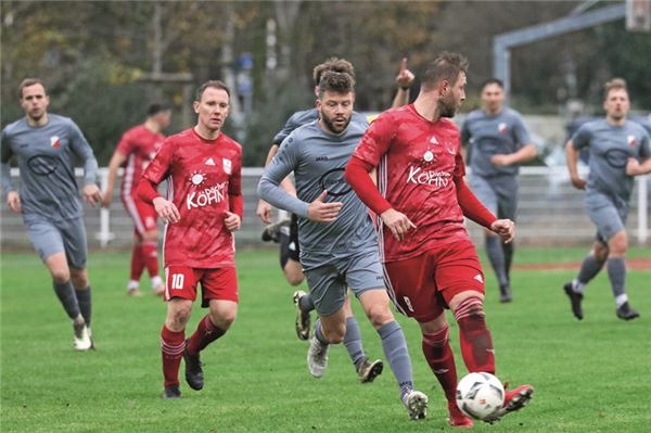 Schulterblick. Unter anderem wollen die rot gekleideten Norderneyer Renke Fischer (vorn) und Jens Harms den auf dem Abstiegsplatz liegenden Verfolger TuS Holtriem im Rückspiegel behalten. Foto: Eibertus Stürenburg