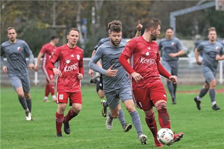 Schulterblick. Unter anderem wollen die rot gekleideten Norderneyer Renke Fischer (vorn) und Jens Harms den auf dem Abstiegsplatz liegenden Verfolger TuS Holtriem im Rückspiegel behalten. Foto: Eibertus Stürenburg