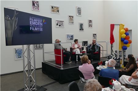 Seinen Eintritt ins Rentneralter hat er glatt vergessen: Emil Steinberger (rechts) mit seiner Frau Niccel und Volker Bergmeister] beim Film-Tee im Atrium der Emder Kunsthalle. Foto: Werner Jürgens