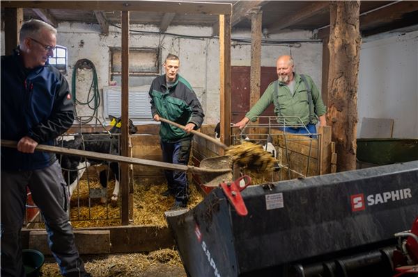 Stephan (M.) muss auf dem Hof von Dieter Hattermann (r.) richtig mit anpacken. Auch sein Betreuer von der Behindertenhilfe durfte nicht faul herumstehen.