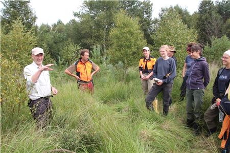 Tido Bent (l.) erklärt den Teilnehmenden die Besonderheiten der Ochsenweide. Foto: Landesforsten