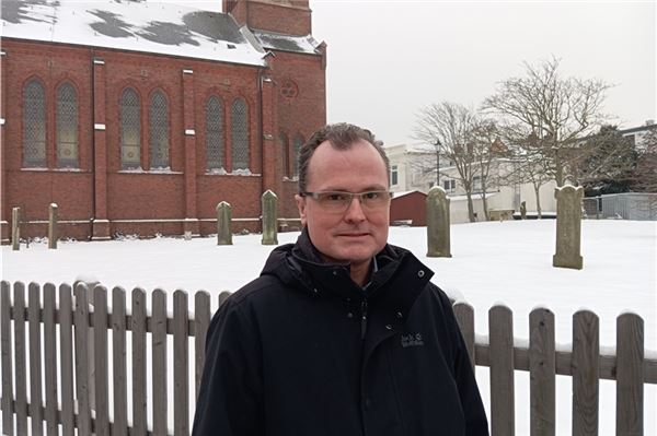 Übt seinen Traumberuf aus: Pastor Stephan Bernhardt vor der Inselkirche. Foto: Privat